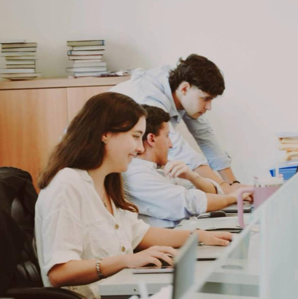grupo de jóvenes profesionales trabajando en un escritorio con computadoras